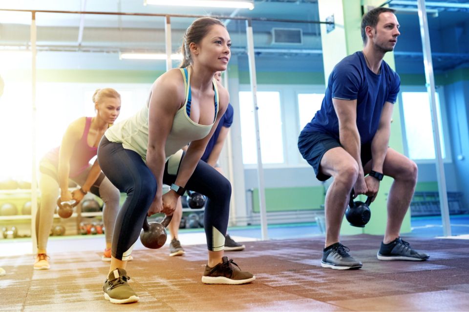 Workout class doing kettlebell deadlifts